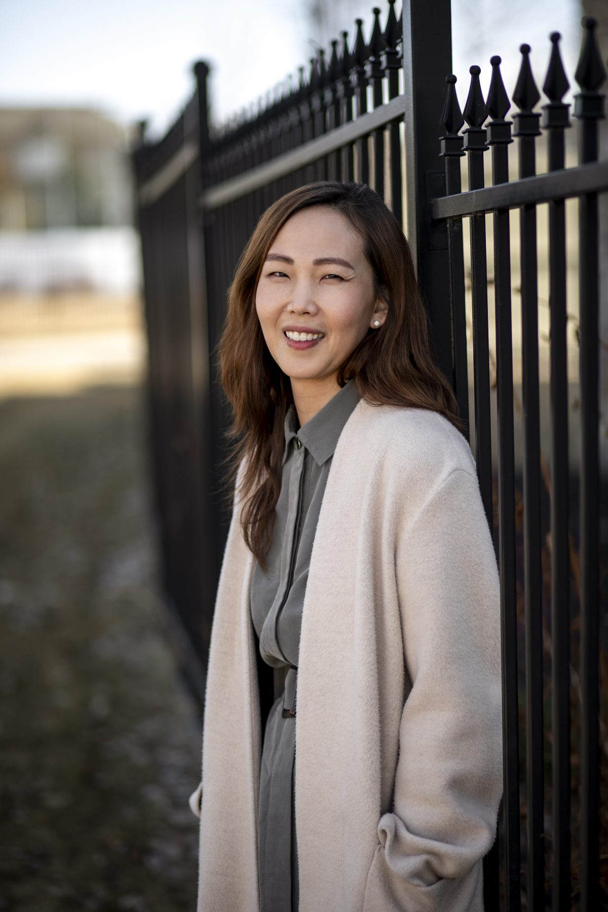 Bona Kim CPA, CMA smiles at the camera in front of a black fence.