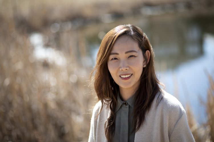 Bona Kim CPA, CMA smiles at the camera with a blurred background of a pond.