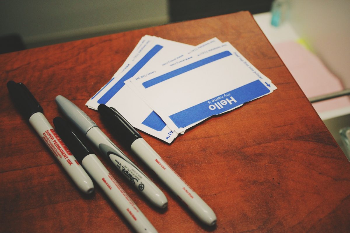 Nametags and sharpies sit on a tabletop.