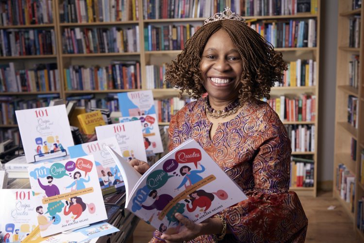 Ada Adeleke-Kelani CPA, CA is smiling at the camera and holding her book titled '101 Quips and Quotes'.