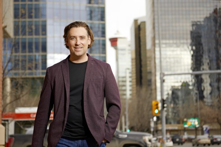 Image of John Thorpe CPA, CMA smiling at the camera while outside with buildings visible behind.