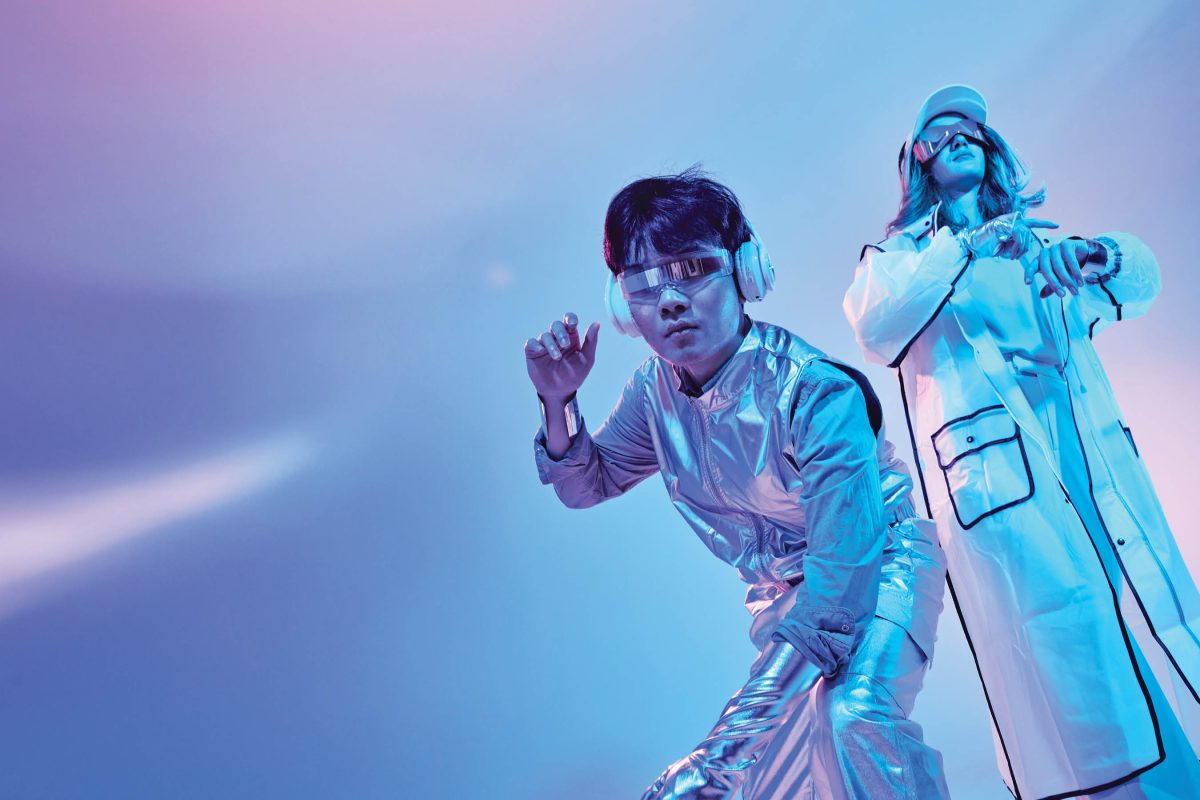 Two people in futuristic clothing pose.