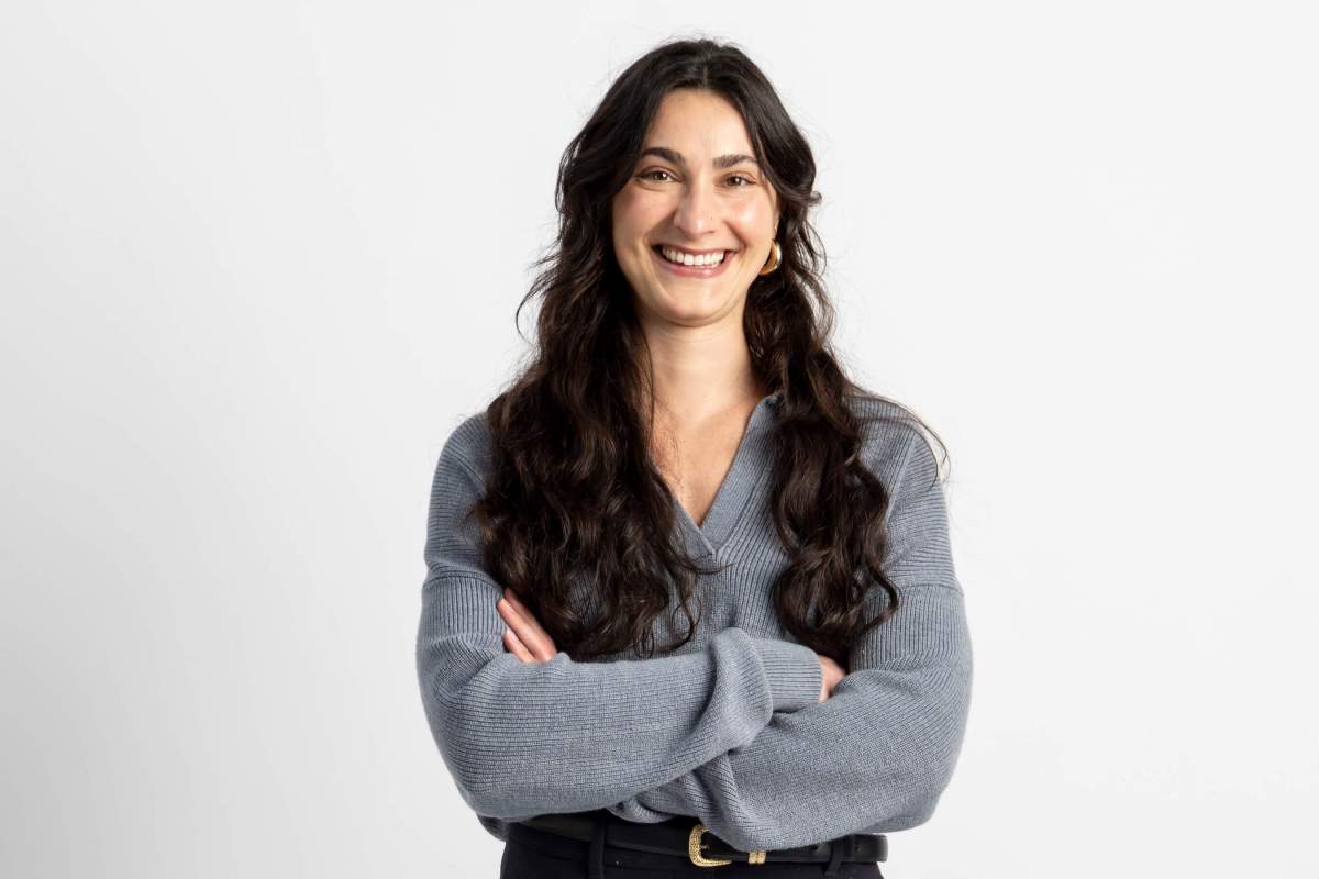 Matia smiles at the camera with her arms crossed in front of her.